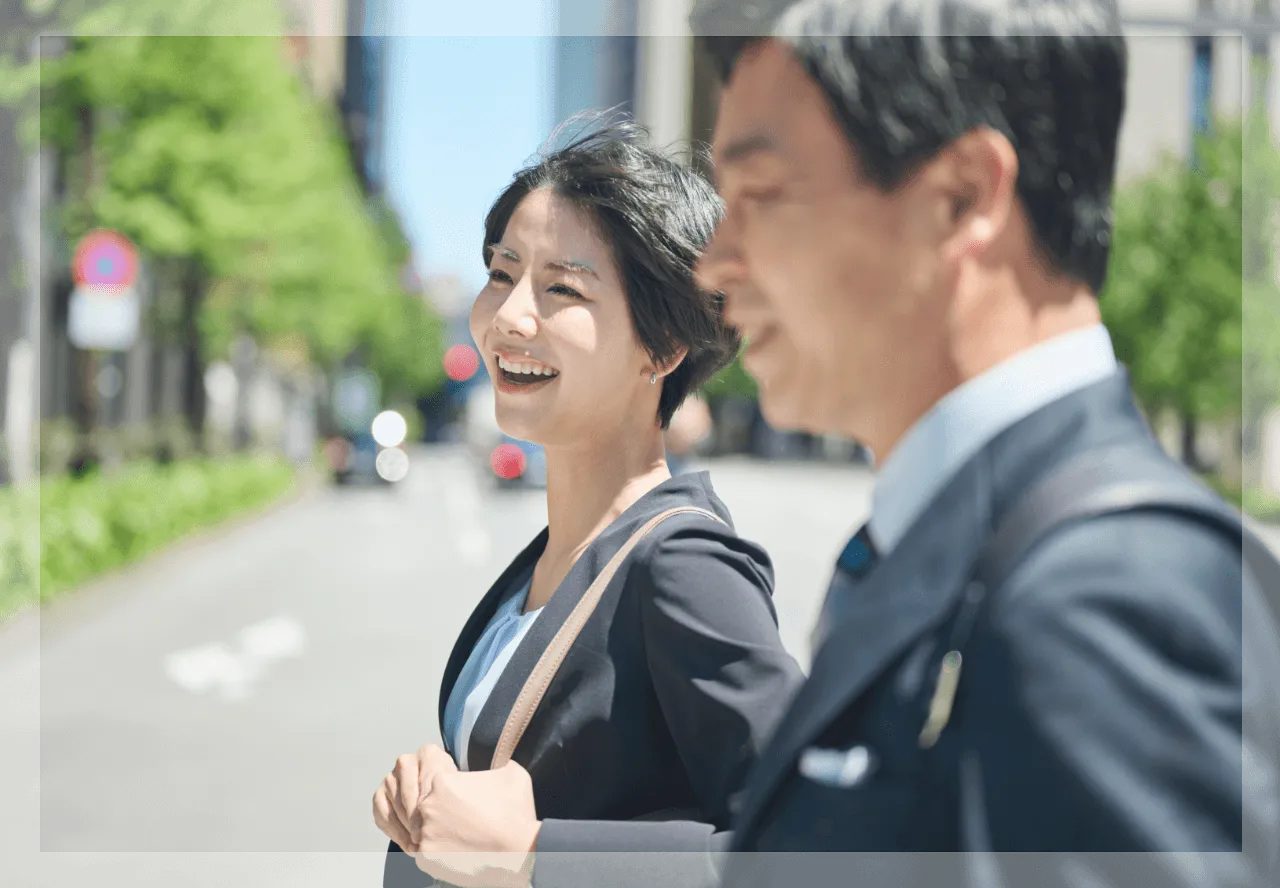 ビジネススーツを着た男性と女性が歩道を歩いている